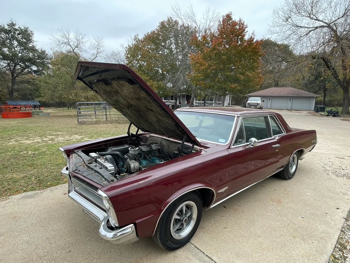 1965 Pontiac GTO front end showing its vertically stacked headlights, hood open